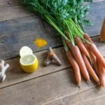 carrot and green vegetable on brown wooden table